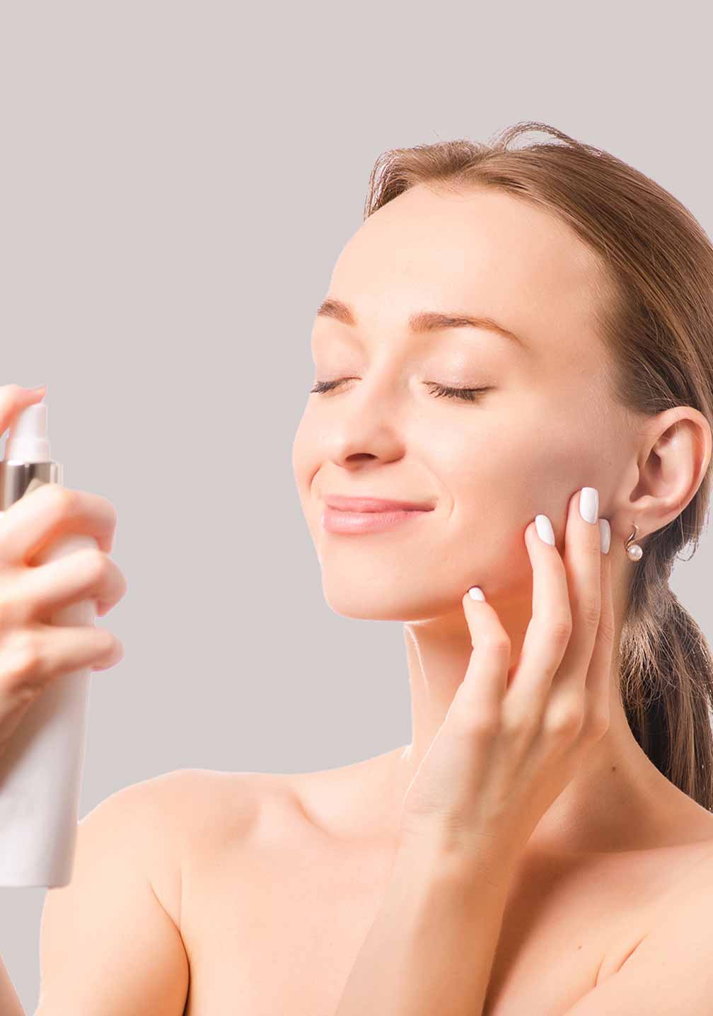 Junge Frau mit natürlicher Haut präsentiert RAU Cosmetics Silber Sprühflasche für Hautpflege gegen Irritationen.